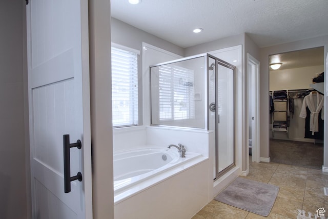 bathroom featuring shower with separate bathtub, a textured ceiling, and tile patterned floors