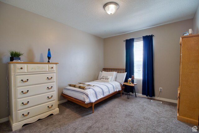 bedroom with a textured ceiling and carpet floors