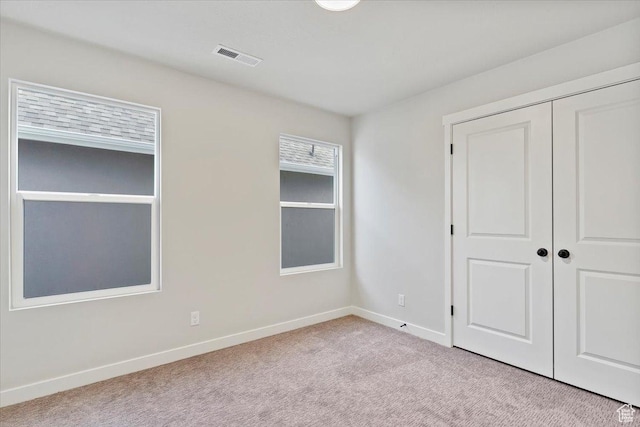 unfurnished bedroom featuring carpet flooring, baseboards, and a closet