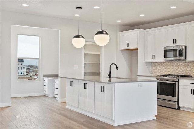 kitchen featuring stainless steel appliances, a sink, white cabinetry, and recessed lighting