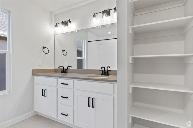bathroom featuring tile patterned flooring, double vanity, and baseboards