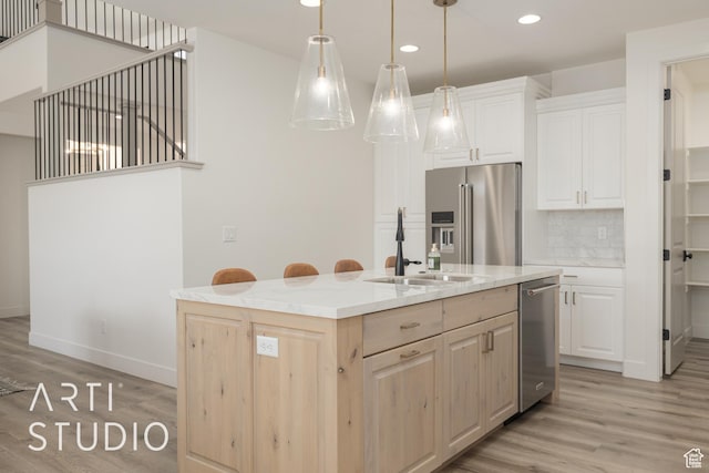 3235 S Retreat Dr, Hurricane, UT 84737 - kitchen featuring stainless steel appliances, an island with sink, pendant lighting, decorative backsplash, and light wood-type flooring
