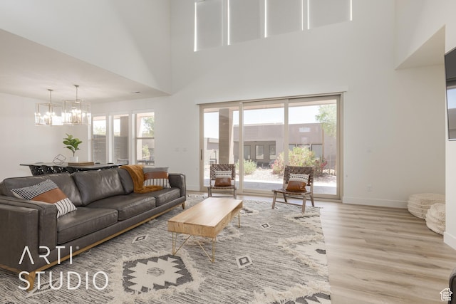 3235 S Retreat Dr, Hurricane, UT 84737 - living room with light wood-type flooring, a towering ceiling, and a notable chandelier