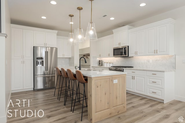 3235 S Retreat Dr, Hurricane, UT 84737 - kitchen featuring a kitchen island with sink, hanging light fixtures, sink, appliances with stainless steel finishes, and white cabinetry