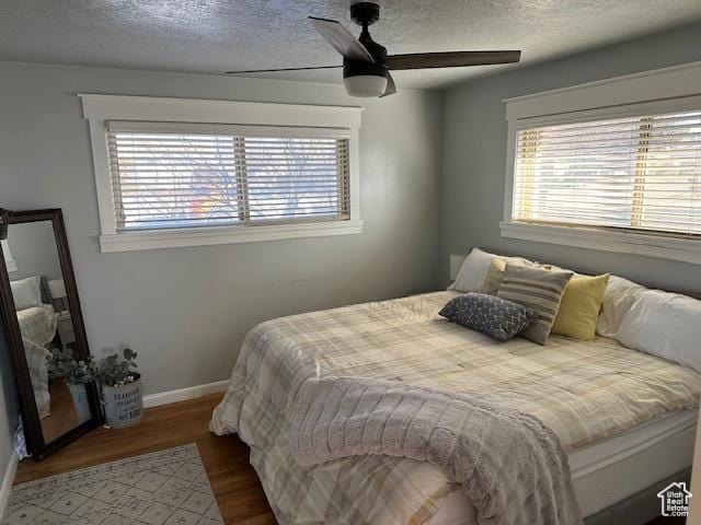 2429 W 300 N, West Point, UT 84015 - bedroom featuring multiple windows, ceiling fan, a textured ceiling, and hardwood / wood-style flooring