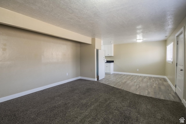 unfurnished living room with carpet and a textured ceiling