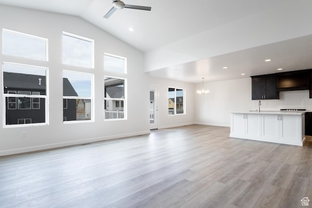 695 S 3550 W Unit 137, West Weber, UT 84401 - unfurnished living room with ceiling fan with notable chandelier, light hardwood / wood-style floors, lofted ceiling, and sink