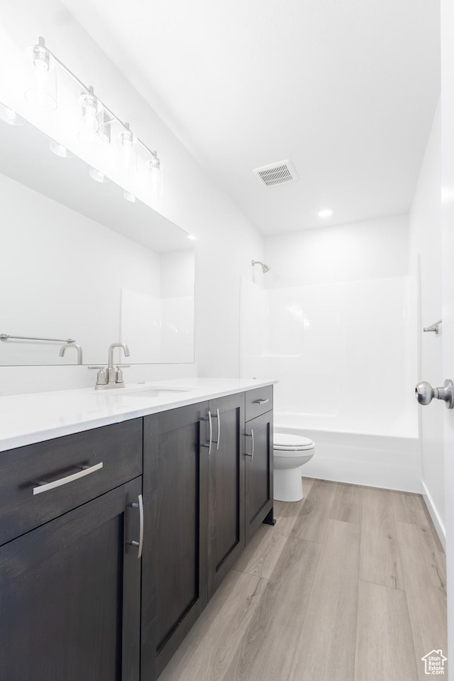 695 S 3550 W Unit 137, West Weber, UT 84401 - full bathroom featuring washtub / shower combination, hardwood / wood-style floors, vanity, and toilet