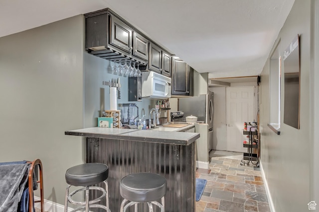 563 W Kalia Cv, Murray, UT 84123 - kitchen with sink, kitchen peninsula, and a breakfast bar area