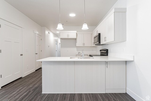 13714 S Hanley Ln Unit Hh204, Riverton, UT 84096 - kitchen with appliances with stainless steel finishes, a sink, a peninsula, baseboards, and dark wood-style flooring