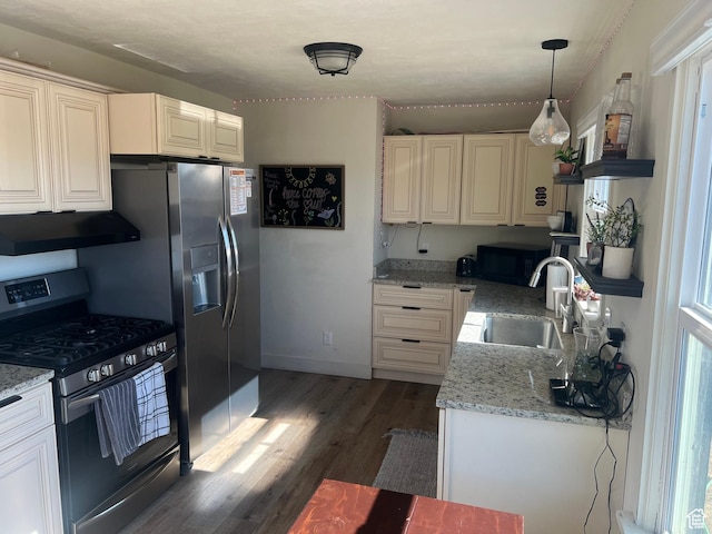 kitchen with light stone countertops, exhaust hood, sink, pendant lighting, and stainless steel range with gas stovetop