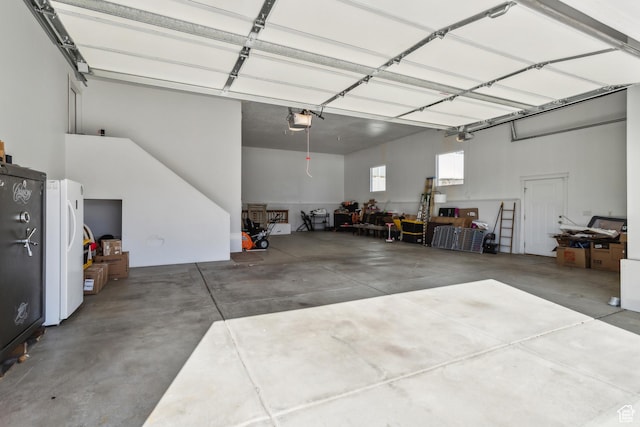 garage with freestanding refrigerator and a garage door opener