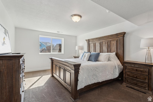 bedroom featuring dark carpet and baseboards