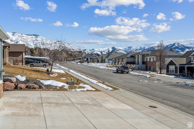 view of street with a residential view, a mountain view, and sidewalks