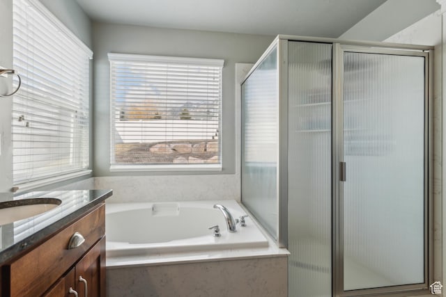 bathroom with a stall shower, a garden tub, and vanity