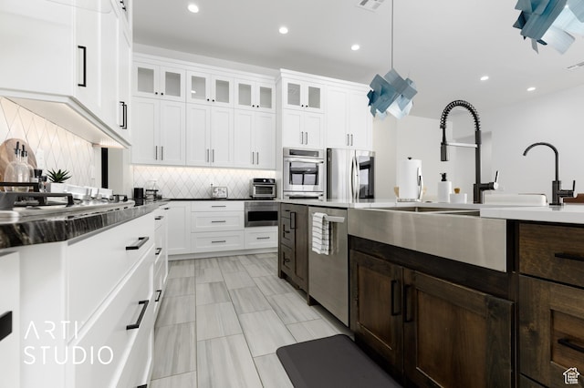 5090 W 3175 S, Hurricane, UT 84737 - kitchen featuring white cabinets, backsplash, stainless steel appliances, and hanging light fixtures