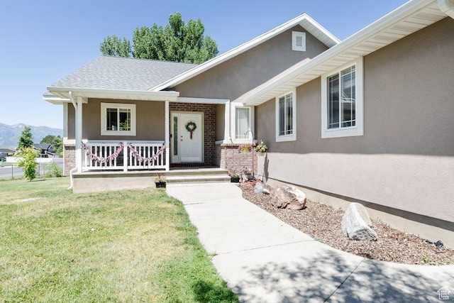 view of front of property with a mountain view, a front lawn, and a porch