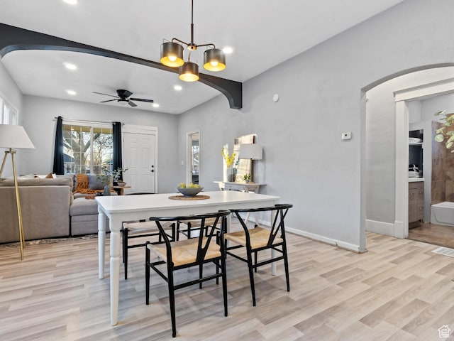 dining room featuring ceiling fan with notable chandelier and light hardwood / wood-style floors