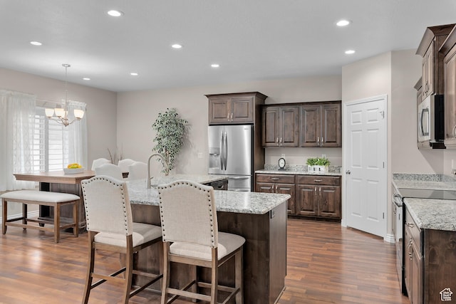 649 E 5650 S, Washington Terrace, UT 84405 - kitchen featuring light stone counters, stainless steel appliances, decorative light fixtures, an inviting chandelier, and dark hardwood / wood-style floors