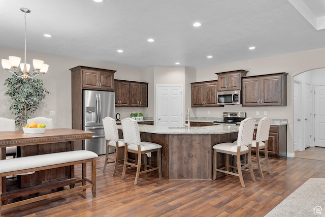 649 E 5650 S, Washington Terrace, UT 84405 - kitchen with a center island with sink, hanging light fixtures, light stone counters, dark hardwood / wood-style flooring, and stainless steel appliances