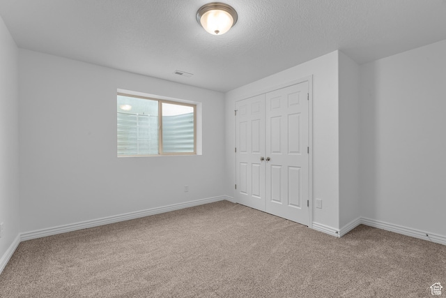 649 E 5650 S, Washington Terrace, UT 84405 - unfurnished bedroom with carpet flooring, a textured ceiling, and a closet