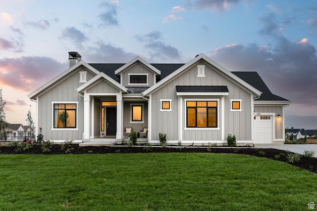 view of front facade featuring a yard, a porch, and a garage