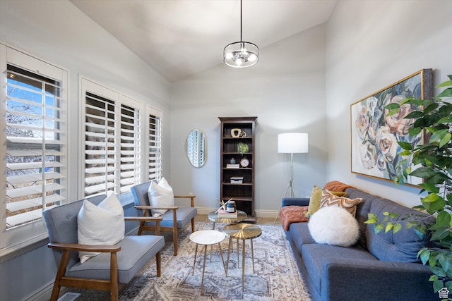 living room with vaulted ceiling and a notable chandelier