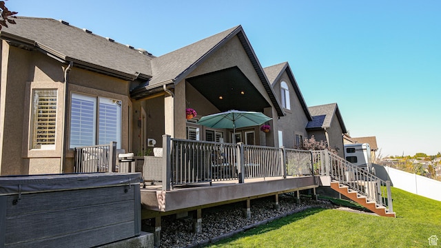 rear view of property with a yard and a deck