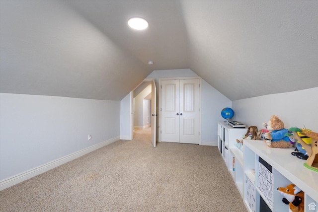 additional living space featuring light colored carpet, lofted ceiling, and a textured ceiling