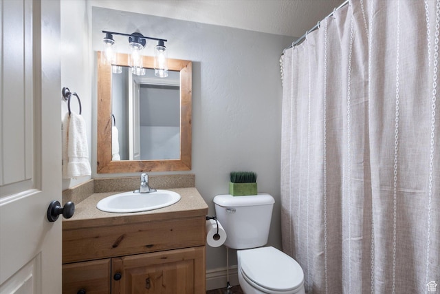 bathroom with a textured ceiling, vanity, toilet, and a shower with curtain