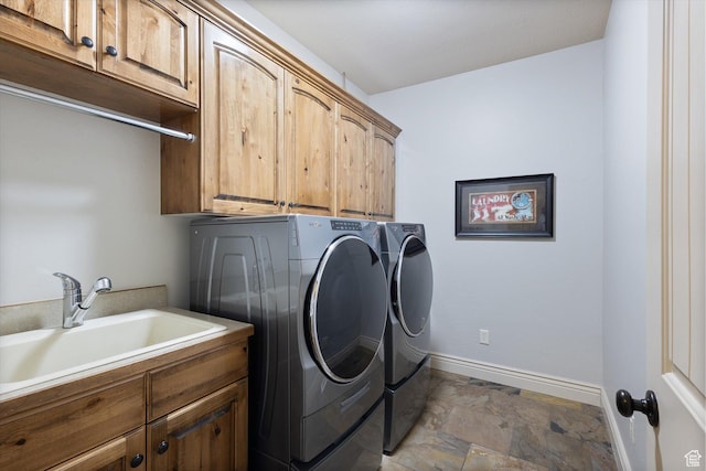laundry room with cabinets, separate washer and dryer, and sink