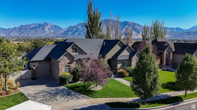 view of front of home with a mountain view, a garage, and a front yard