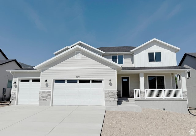 3241 S Red Wolf Dr, Saratoga Springs, UT 84045 - view of front of home featuring a porch, stone siding, an attached garage, driveway, and board and batten siding