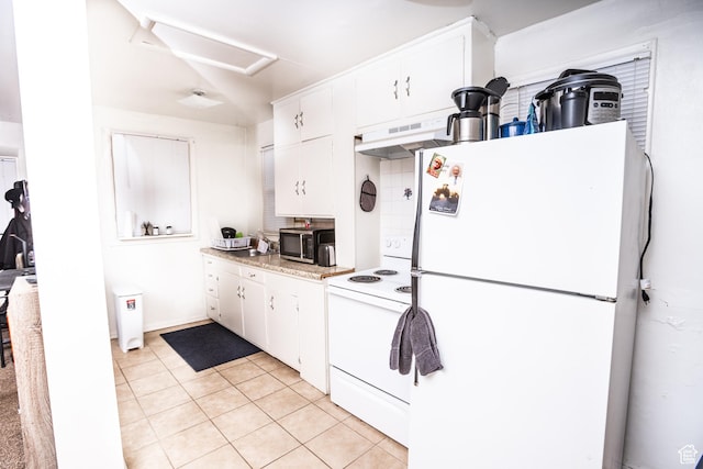 128 N 8th St, Montpelier, ID 83254 - kitchen with light countertops, white appliances, light tile patterned floors, under cabinet range hood, and white cabinets