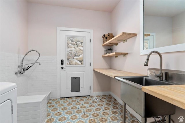 13802 S Mount Shaggy Dr, Herriman, UT 84096 - kitchen featuring butcher block counters, sink, and washer / dryer
