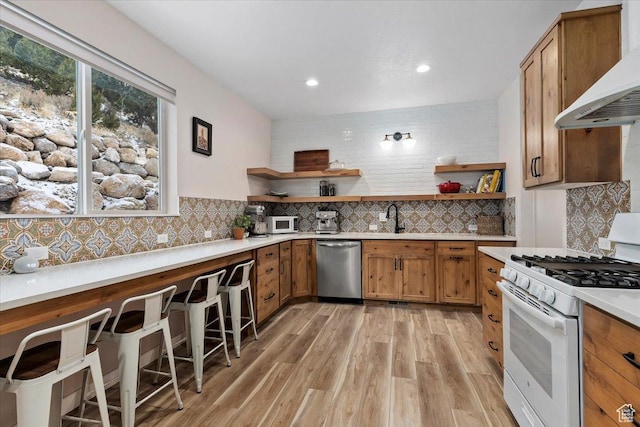 13802 S Mount Shaggy Dr, Herriman, UT 84096 - kitchen with white appliances, backsplash, wall chimney range hood, sink, and light hardwood / wood-style floors