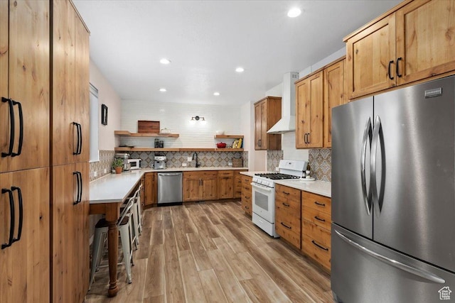 13802 S Mount Shaggy Dr, Herriman, UT 84096 - kitchen with sink, wall chimney exhaust hood, stainless steel appliances, light hardwood / wood-style floors, and decorative backsplash