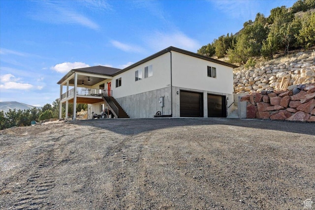 13802 S Mount Shaggy Dr, Herriman, UT 84096 - view of side of home with a deck with mountain view, a garage, and ceiling fan