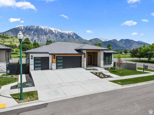 1302 N 750 E, Orem, UT 84097 - view of front of property featuring stone siding, an attached garage, a mountain view, and driveway