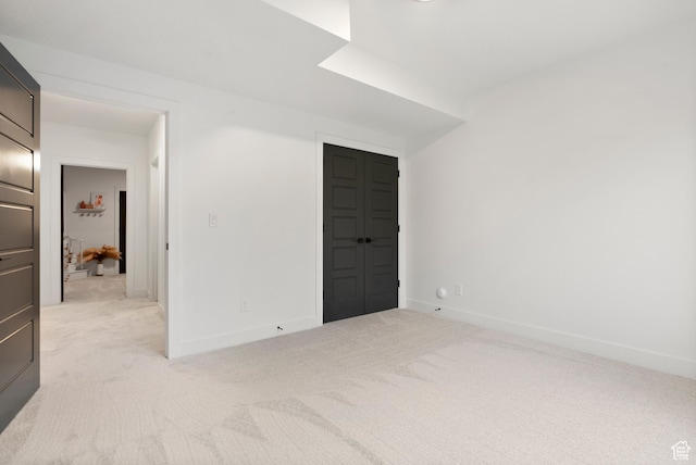 spare room featuring light carpet
