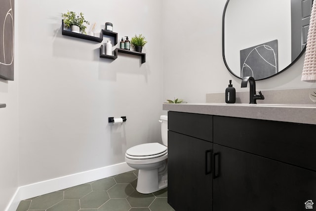 bathroom with toilet, vanity, and tile patterned floors