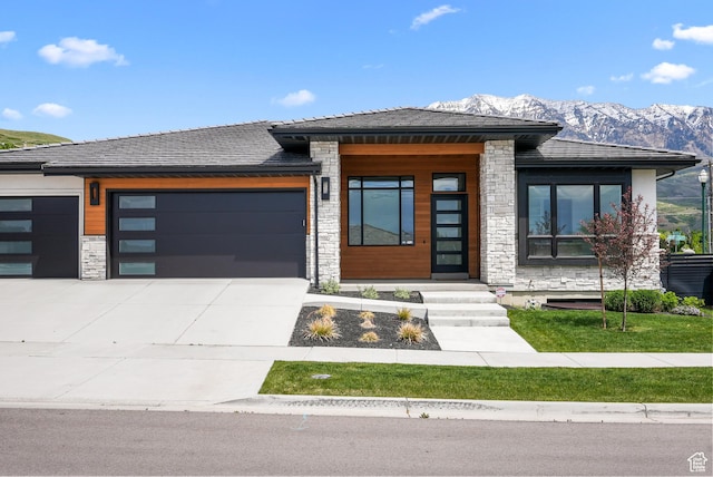 1302 N 750 E, Orem, UT 84097 - view of front of home featuring stone siding, a garage, a mountain view, and concrete driveway