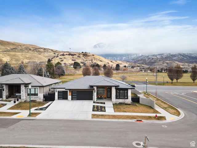 view of front of home with covered porch, a mountain view, and a garage