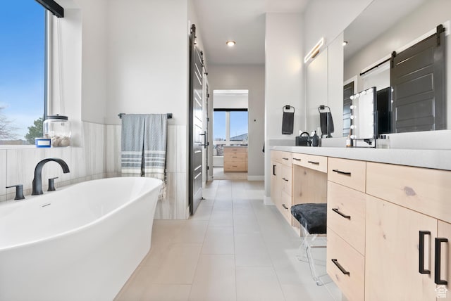 bathroom with tile patterned floors, vanity, and a bath