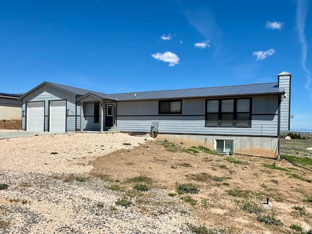 3092 S Country Club Way, Garden City, UT 84028 - view of front of property featuring a chimney, a garage, driveway, and metal roof