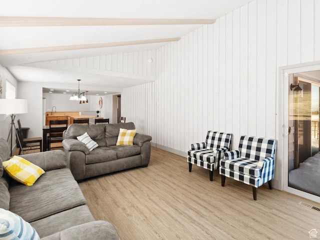 3092 S Country Club Way, Garden City, UT 84028 - living room with light wood finished floors, lofted ceiling with beams, visible vents, and a notable chandelier