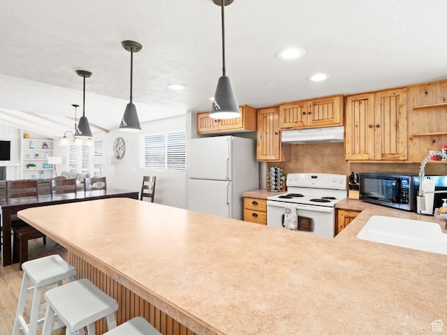 3092 S Country Club Way, Garden City, UT 84028 - kitchen featuring hanging light fixtures, light countertops, white appliances, a peninsula, and under cabinet range hood