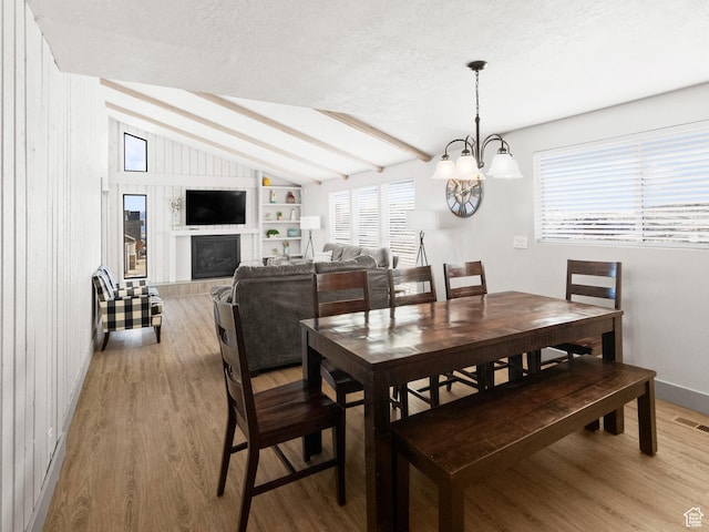 3092 S Country Club Way, Garden City, UT 84028 - dining room with a textured ceiling, visible vents, a chandelier, vaulted ceiling with beams, and light wood finished floors