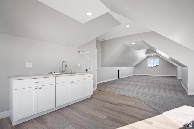 interior space featuring light hardwood / wood-style flooring, lofted ceiling, and sink