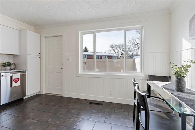 dining space with ornamental molding and a textured ceiling
